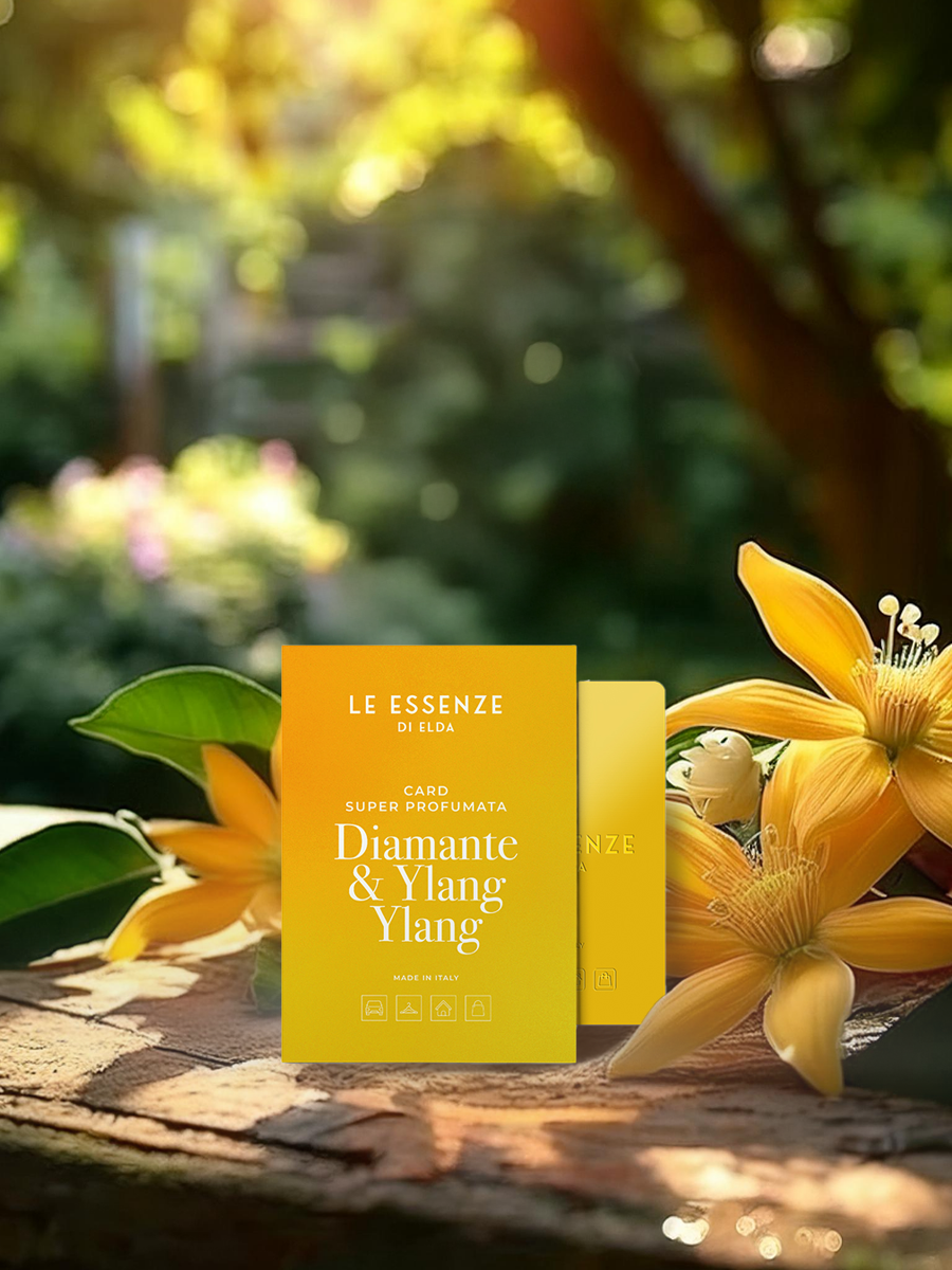 Yellow perfume bottle labeled 'Le Essenze' with flowers in a garden setting