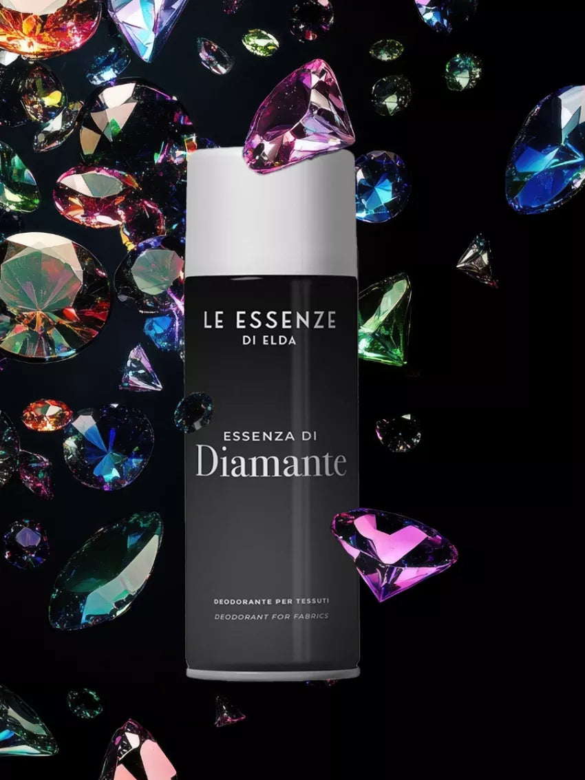Diamante textílsprey 400ml frá Le Essenze di Elda í dökkgráum úðabrúsa með hvítu loki, umkringt litríkum skrautsteinum á svörtum bakgrunni.