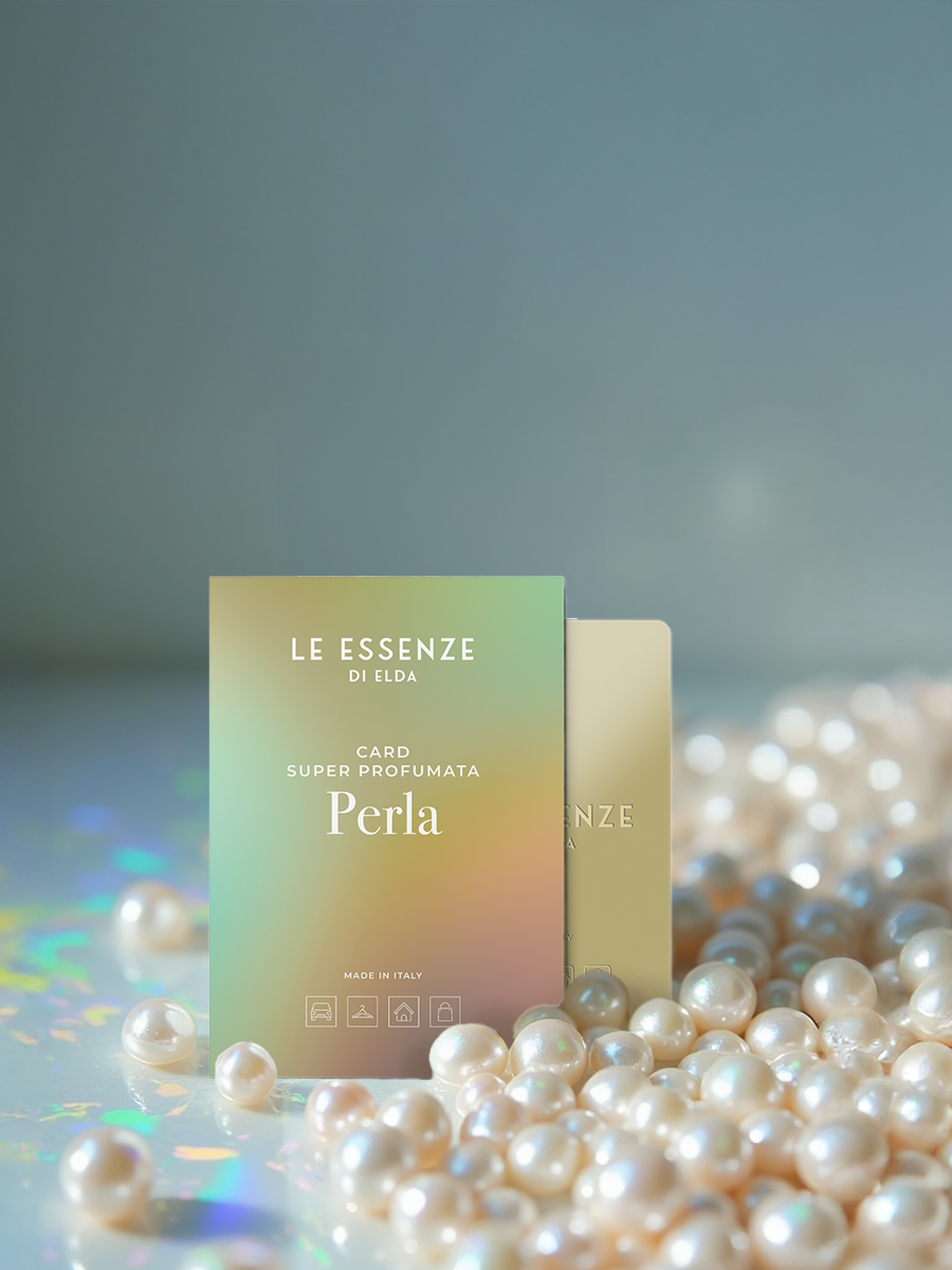 Perfume packaging with 'Le Essenze di Elda' branding on a gray background with pearls.
