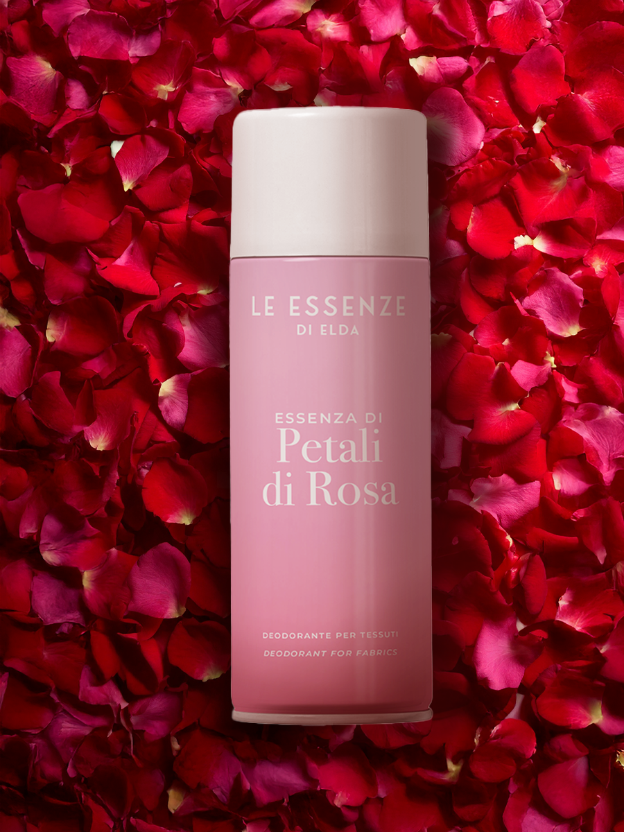 Deodorant bottle with 'Le Essenze di Elda' on a bed of red rose petals
