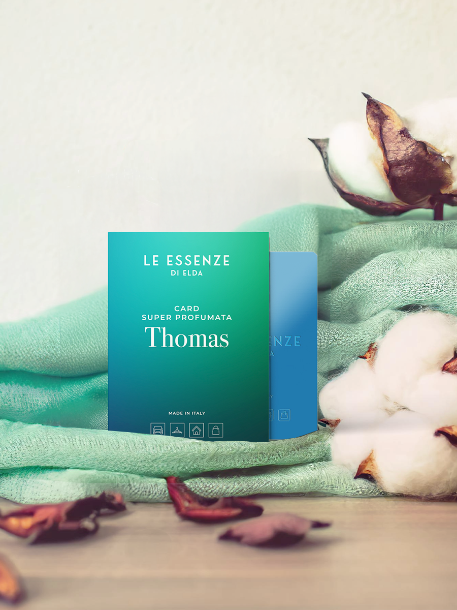 Candle packaging labeled 'Le Essenze di Elena' with cotton and dried flowers on a light background